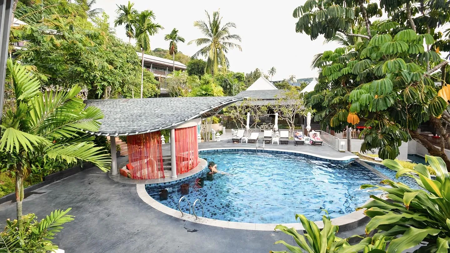 The beach resort’s multi-tiered swimming pool, surrounded by lush tropical greenery and lounge areas, offers a serene and inviting space for relaxation